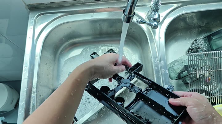 Washing black plastic rack in sink Washing black plastic rack in sink