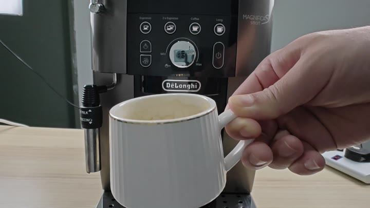 White mug placed under coffee spout White mug placed under coffee spout