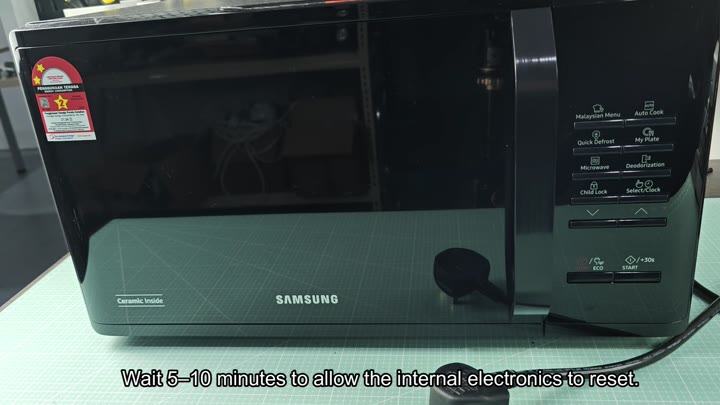 Black Samsung microwave on green mat Black Samsung microwave on green mat