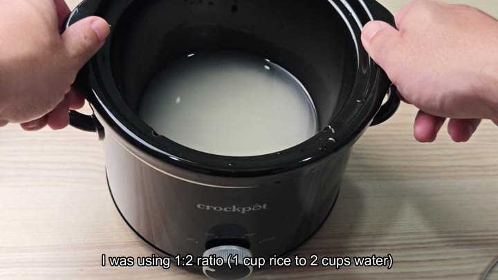 Black slow cooker filled with rice and water Black slow cooker filled with rice and water