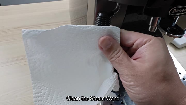 Cleaning the steam wand with paper towel Cleaning the steam wand with paper towel