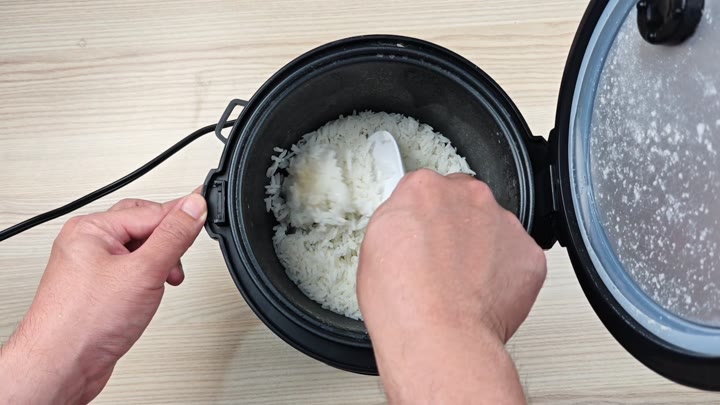 Fluffing cooked white rice inside Fluffing cooked white rice inside