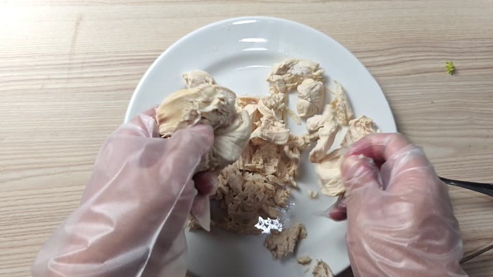 Hand tearing chicken into pieces Hand tearing chicken into pieces