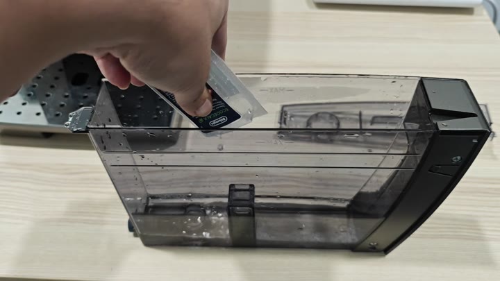 Inserting DeLonghi ECOCLEAN cartridge into tank Inserting DeLonghi ECOCLEAN cartridge into tank
