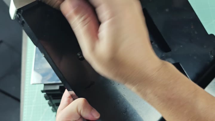 Inspecting black plastic housing on mat Inspecting black plastic housing on mat