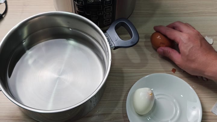 Peeling hard-boiled egg on counter Peeling hard-boiled egg on counter