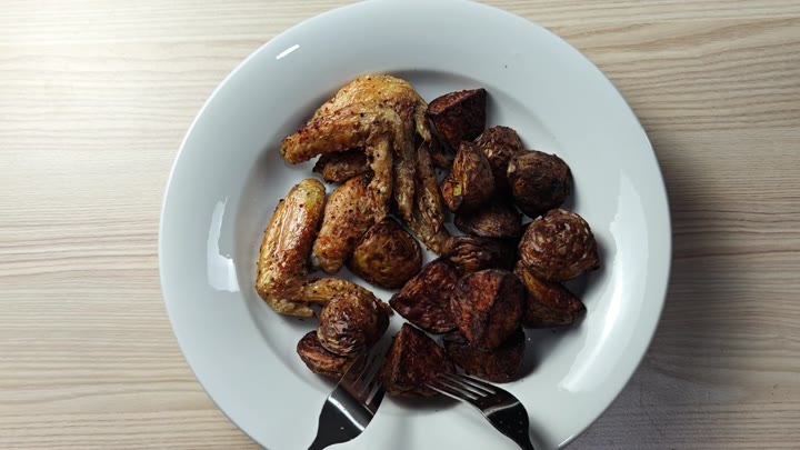 Plated wings and roasted potato wedges Plated wings and roasted potato wedges