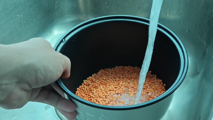 Rinsing red lentils under water Rinsing red lentils under water
