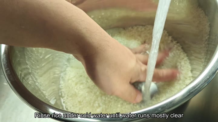 Rinsing white rice in a stainless steel bowl Rinsing white rice in a stainless steel bowl