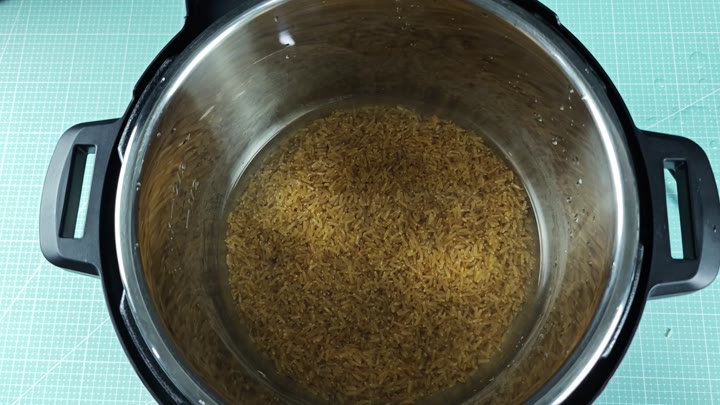 Uncooked brown rice and water in pot Uncooked brown rice and water in pot