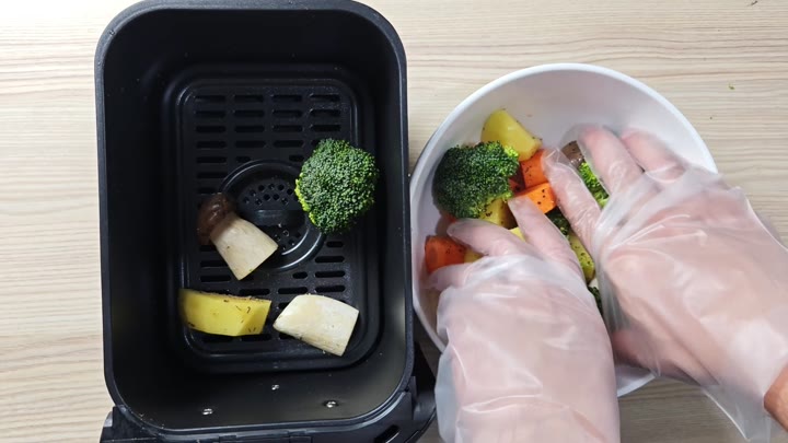 Vegetables going into air fryer basket Vegetables going into air fryer basket