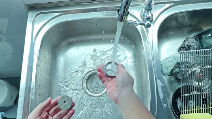 Washing circular metal components under tap Washing circular metal components under tap
