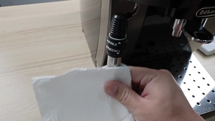 Wiping steam wand with paper towel Wiping steam wand with paper towel